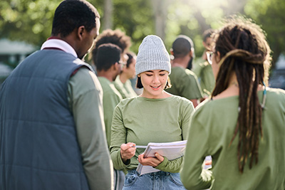 Volunteer with a Clipboard Asking a Man and a Woman Questions Outside