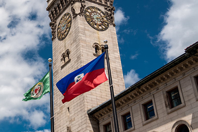 City Hall Clock Tower and Two Flag Poles One Flying the City of Worcester Flag and the Other a Cultural Flag