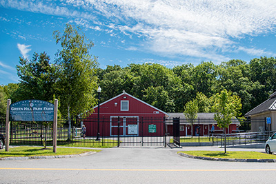 Entryway and Barn for Green Hill Park with Parking Lot and Cars