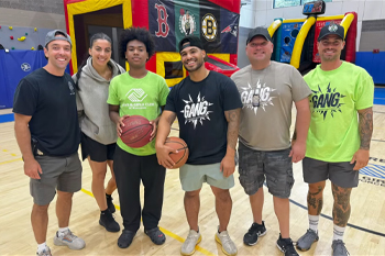 WPD Officers and Youth Standing Beside Each Other in Gym Holding Basketballs