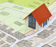 Map on Table Showing Zoning Area with 3D House Graphic Sitting On Top