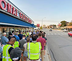 Group of People on Sidewalk Doing Walk Audit of a Busy City Street