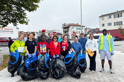 Clean Team Members with Trash Bags after Picking Up Trash on Sidewalk