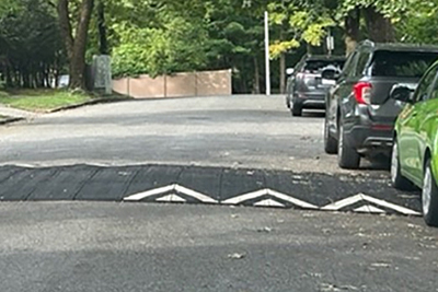 Temporary Speed Hump Installation on City Street with Cars Parked to the Right